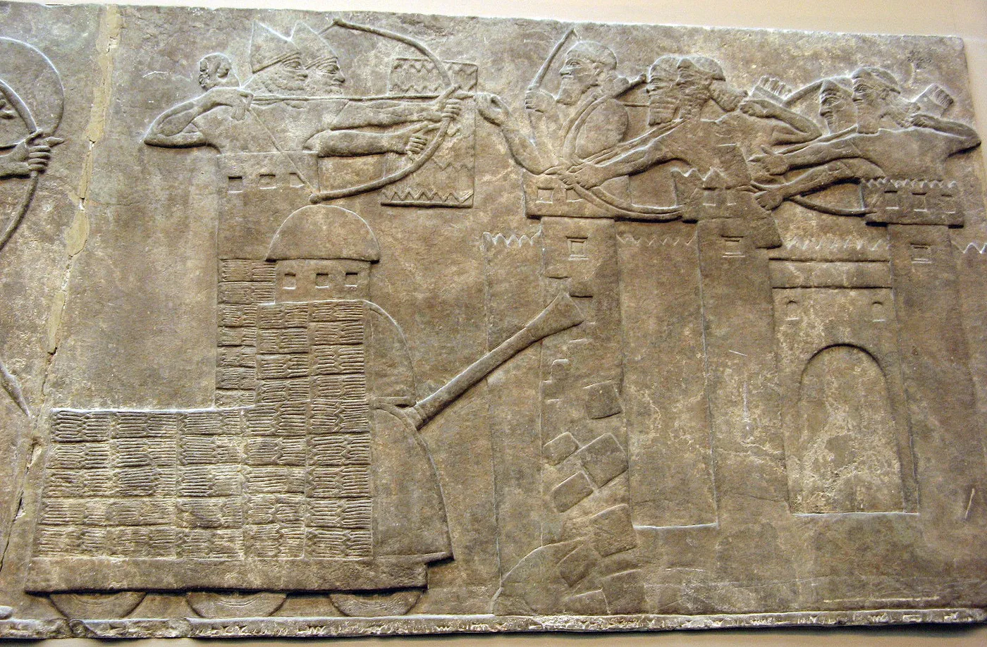 Siege tower and battering ram destroying the walls of a fortified city, Assyrian relief