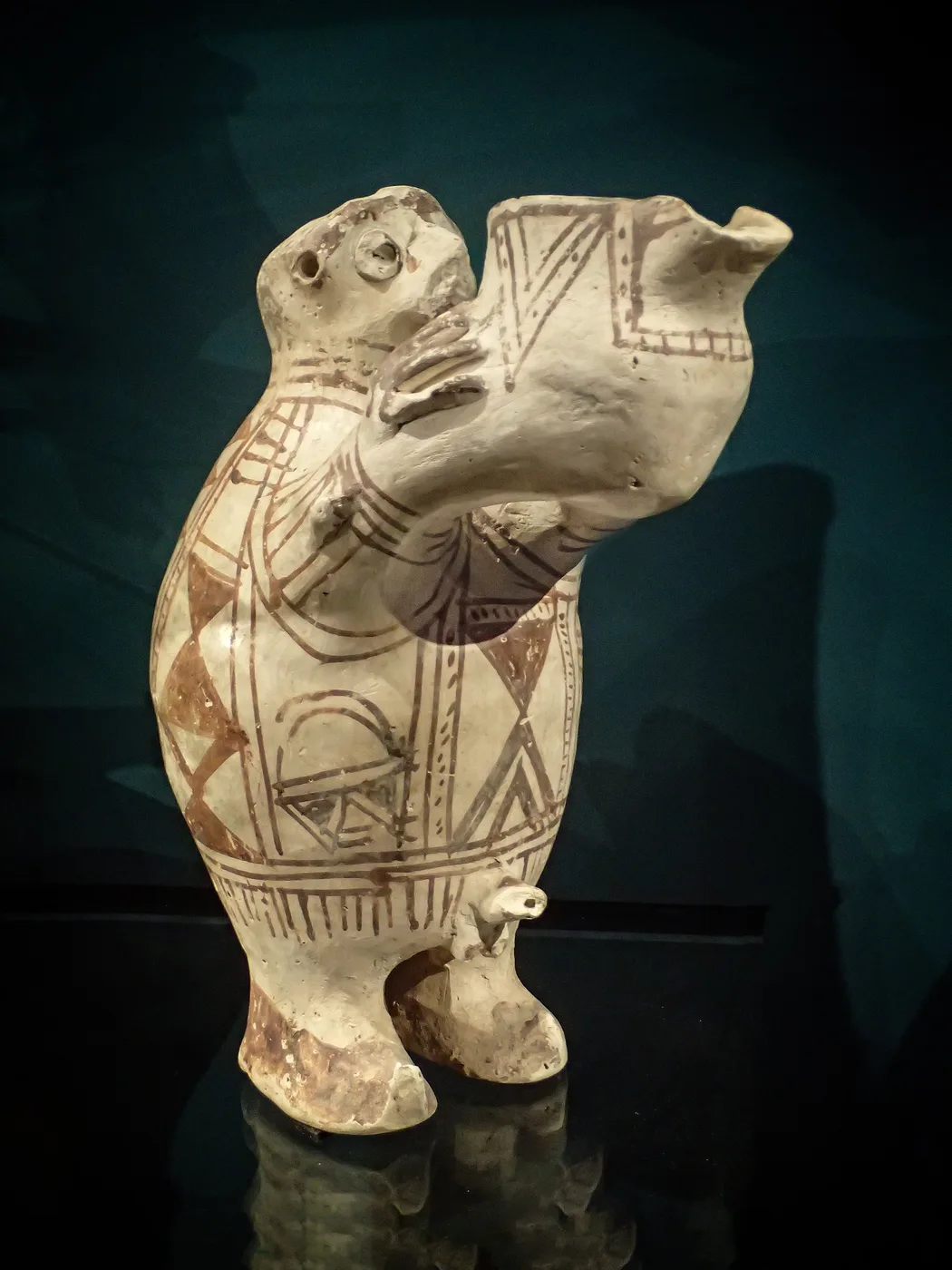 A ceramic figure with a libation jar