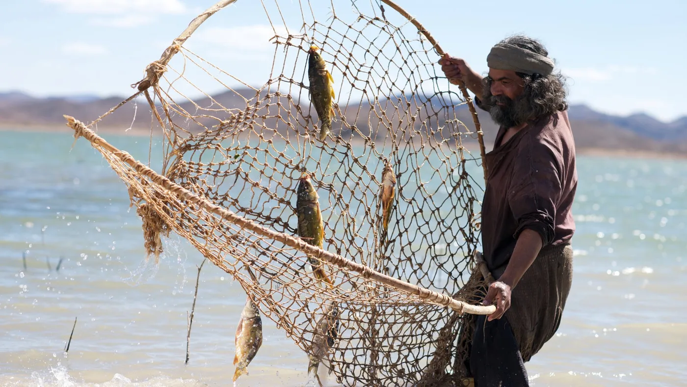 Fisherman casting his net from a boat